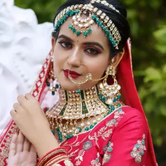 A close-up portrait of the bride, focusing on the intricate details of her matha patti, nath, and choker.