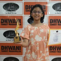 A young student proudly holds her certificate and trophy. We nurture talent and dedication, helping students build discipline that benefits all areas of life.