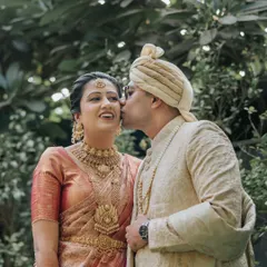 A sweet kiss on the cheek. This candid moment between the South Indian bride and her Punjabi groom perfectly encapsulates the love and joy of their fusion wedding.