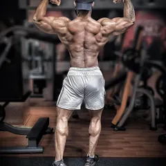 A classic back double biceps pose, highlighting the development of the lats, traps, and arms. A strong back is the centerpiece of a powerful physique, and I build mine with heavy, foundational movements.
