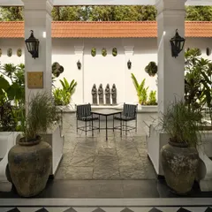 The foyer at Elgin Cafe acts as a threshold between the exterior and interior worlds. Symmetrical columns frame a view into the tranquil courtyard, establishing a sense of formal procession and calm.