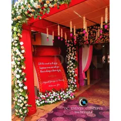 A closer look at a vibrant red-themed entrance. The personalized welcome scroll and hanging floral tassels add intricate details that make the entryway special and inviting.