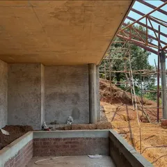 The swimming pool and stage area for the Kaivalyam Yoga retreat under construction. The design uses the site's slope to create two distinct levels for privacy and public functions.