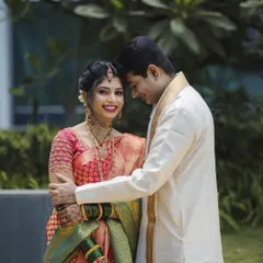 A classic pose with a modern feel. This portrait of Roshan and Meenakshi showcases her beautiful bridal saree and the groom's elegant attire, capturing a moment of quiet affection between them.