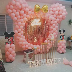 A cute Minnie Mouse theme for a third birthday. The centerpiece is a large Minnie head silhouette made entirely of pink balloons, with a golden bow and a shimmer backdrop in the middle.