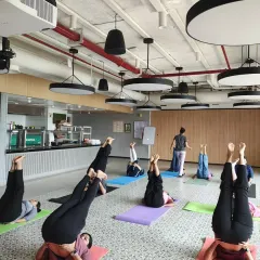 Participants practicing Sarvangasana (Shoulder Stand) variation, an inversion that helps calm the mind and improve circulation.