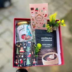 Get cozy for the holidays with our signature Christmas hamper. This set includes a festive mug, a jar of sweet treats, and premium Swiss vanilla hot chocolate mix, all beautifully arranged in a red gift box. It's the perfect warm and thoughtful gift for friends, family, or colleagues.