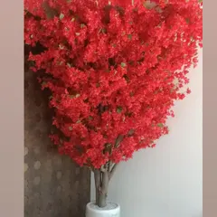 A magnificent, full-bloom red flowering tree in a white marble pot, designed to be a dramatic and colorful centerpiece.