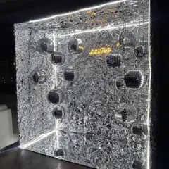 A unique 3D photo op. This silver shimmer cube is lit with neon strips and filled with disco balls, creating a futuristic and immersive space for guests to take pictures.