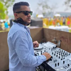 A candid shot of me at the console during a daytime mehndi in Goa. My focus is always on the music and the crowd's reaction.