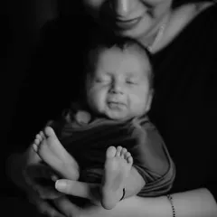 A precious black and white close-up of a newborn's sleepy smile and tiny feet. These detail shots are essential for remembering just how small they once were.