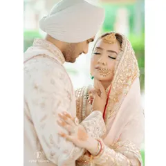 An intimate portrait of the couple, their eyes closed in a moment of quiet connection, highlighting the delicate details of their pastel wedding outfits.