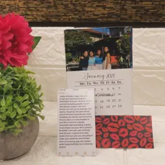 A custom desk calendar from last year, featuring a personal photo for each month and a wooden stand. I can create these for the new year with your favorite pictures and important dates.