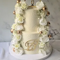 It was an honor to create this engagement cake for a loyal client. This two-tier design is adorned with columns of fresh white flowers and baby's breath, accented with gold spheres and a custom initial topper.