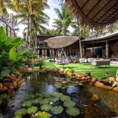 A serene, natural pond teeming with life becomes the centerpiece of this outdoor living design. We crafted this space to be a private oasis, blending manicured lawns with wilder, natural elements for a truly immersive experience.