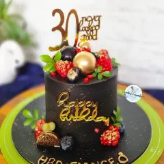 Milestone moments deserve a statement cake. This 30th birthday cake features a rich black buttercream, elegant gold script, and a topping of fresh berries for a touch of luxury.