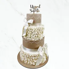 For Ujjwal and Sukriti's wedding, we created this stunning four-tier cake. The combination of delicate ruffles and elegant satin bows gives it a romantic and sophisticated feel.