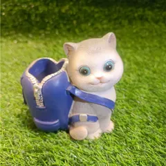 A sweet grey cat pen holder with a blue backpack. It's a whimsical and practical item for anyone who loves feline friends.