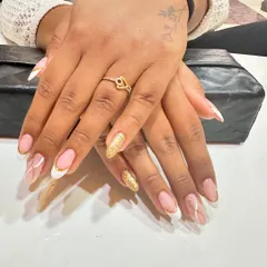 A fun and stylish take on the French manicure. This set features classic white tips, a full gold glitter accent nail, and delicate white swirls on a natural base.