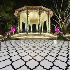 An immaculate Sangeet setup. We flanked the grand, domed stage with two magnificent pink peacocks, their floral tails cascading down, creating a truly show-stopping entrance to the dance floor.