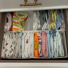 A drawer full of adorable, file-folded baby clothes. This method allows parents to see every outfit at a glance, making dressing a wriggly little one much faster.