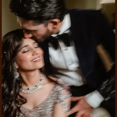 A beautiful, motion-blurred shot of a groom kissing his bride's forehead during their engagement. The artistic effect emphasizes the emotion and fleeting magic of the moment.