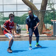 Coaching is about connection and clear instruction. Here, I am working with two young athletes on a reaction drill using tennis balls. This exercise improves hand-eye coordination, cognitive processing, and athletic stance, all critical skills for any sport.
