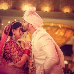 A tender moment as the groom kisses the bride's forehead, a classic and timeless expression of love.