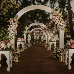 We designed this enchanting floral entrance pathway to create a magical first impression. The series of white arches is adorned with lush arrangements of pastel roses and peonies, with lanterns lining the walkway for a warm, inviting glow at dusk.