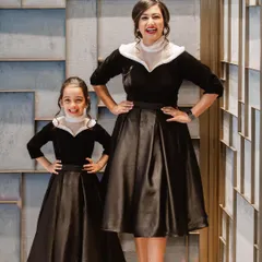 A classic and sophisticated matching set for a mother and daughter. These custom dresses feature a timeless black velvet bodice with a contrasting white collar and a full satin skirt, showcasing a polished and elegant style suitable for formal occasions.