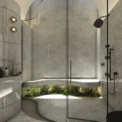 This bathroom embodies refined elegance with its sculptural curved walls clad in grey marble. A glass-enclosed shower with an integrated bench sits beside a small planter, seamlessly blending natural stone with biophilic elements.