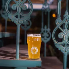 A crisp pint of our craft beer resting on the ornate ironwork of our staircase. It's the perfect companion for a relaxed evening exploring the mansion.