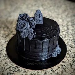 A dramatic "RIP 20s" cake to welcome the 30s. This all-black dark chocolate ganache cake is decorated with black fondant roses, a skull, and a gravestone topper for a bit of gothic humor.