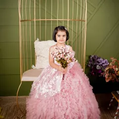 Another look at this gorgeous pink ruffled gown for kids. Here, she is seated on my studio's golden birdcage chair, holding a bouquet of flowers like a true princess.