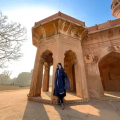 Using the morning sun and grand architecture to create a dramatic silhouette. This wide-angle shot captures the grandeur of the location and the elegance of the traditional blue suit.
