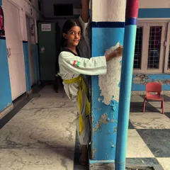 The determination in her eyes says it all. A young student holds a difficult wall split, proving her strength and flexibility.