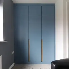 The same blue wardrobe shown with the doors closed, presenting a clean, seamless, and minimalist look.