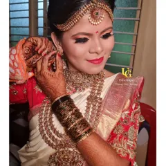A candid moment as Shruthi puts on her earrings. The makeup is designed to look perfect from every angle.