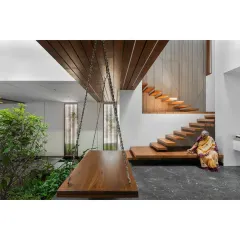 A quiet moment in the Split House, where a traditional wooden swing offers a place for reflection next to the indoor garden. The design combines modern architectural elements with timeless details, creating spaces that are both contemporary and deeply comfortable for every generation of the family.