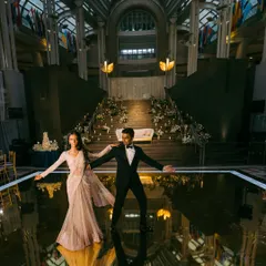 Making an entrance that no one will forget. Nisha and Vishal on the glossy dance floor, perfectly styled to complement the grand, modern architecture of their reception venue. Her sari flows beautifully, and his tux is timeless.