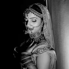 A timeless black and white portrait of a bride in a moment of quiet reflection. The dramatic lighting emphasizes her classic beauty and emotion.