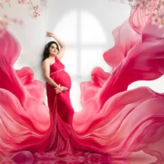This image showcases the incredible visual impact of a flowing fabric gown. The vibrant pink material seems to dance around the mother-to-be, creating a dreamy and artistic maternity portrait.
