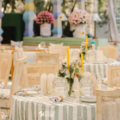Our tablescapes are designed to be a feast for the eyes. Here, striped green and white tablecloths are paired with custom floral menus and simple, elegant centerpieces, creating a fresh and inviting dining setup.