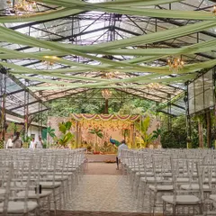 We designed this stunning South Indian wedding mandap in a glasshouse, blending the lush green outdoors with traditional decor. The custom-painted backdrop featuring a majestic peacock and tropical foliage created a vibrant yet sacred atmosphere for the ceremony.