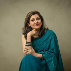 An elegant portrait celebrating personal style. Here, we used a simple, neutral background to let her beautiful teal saree and confident presence shine, creating a timeless and graceful image.