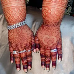 A perfect example of a rich henna stain. Notice the deep color on the palms and fingers, and the personalized heart motif that stands out beautifully.