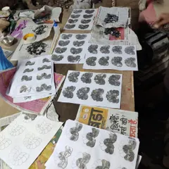 The artisan's workbench, covered in sketches and pieces of Thikri glass. This is where the magic happens, translating a design concept into a tangible piece of art.