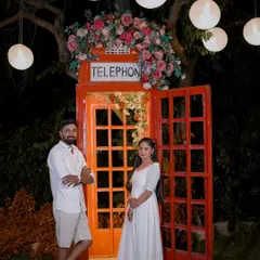 A quirky and fun night shot with a classic red telephone booth prop, decorated with flowers and lights. We have many unique props for your shoot.