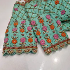 A close-up of the sleeves of the mint green blouse, showing the beautiful floral embroidery that complements the back design.