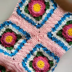 This detail shot shows four of the Lydia blanket's floral squares joined together. The pattern creates a lovely flower-in-a-square motif.